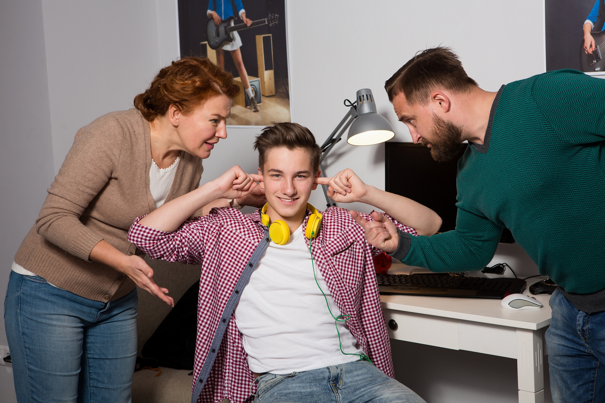 Concept of misunderstanding between generations. Concept of misundrestanding between generations. Teenage boy closed his ears with hands while parents yellling at him.